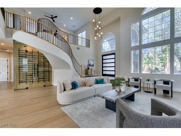 Bright living room features soaring ceilings, staircase, and expansive windows offering abundant natural light at 5573 San Florentine Ave, Las Vegas, NV 89141