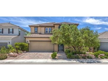 Two story home featuring a paver driveway, desert landscaping, and mature shade trees at 9785 W Meranto Ave, Las Vegas, NV 89178