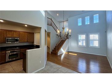 Bright living room features wood floors, high ceilings, and a decorative chandelier at 11404 Belmont Lake Dr # 103, Las Vegas, NV 89135