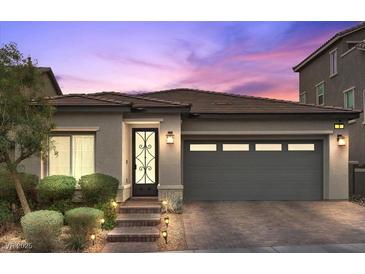 Charming single-story home showcasing a well-manicured yard and a two-car garage with brick driveway at 3 Vicolo Sebino, Henderson, NV 89011