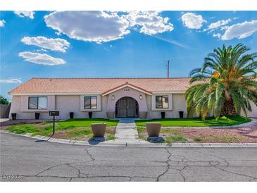 Charming single-story home with a well-manicured lawn and mature palm tree providing curb appeal at 465 E Robindale Rd, Las Vegas, NV 89123
