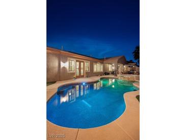 Inviting backyard pool with lush landscaping and patio area, perfect for outdoor entertaining and relaxation at 8149 Villa De La Playa St, Las Vegas, NV 89131