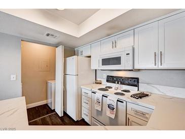 Well-lit kitchen with white cabinets, stainless steel appliances, and a laundry area at 8600 W Charleston Blvd # 1059, Las Vegas, NV 89117
