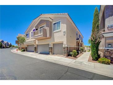 Inviting multi-story townhome with a private balcony, attached garage, and neat landscaping at 8768 Tom Noon Ave # 101, Las Vegas, NV 89178