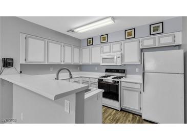 Traditional kitchen featuring white cabinets, laminate countertops, and modern appliances at 2124 Willowbury Dr # D, Las Vegas, NV 89108