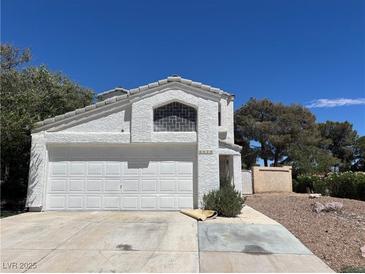 Two-story home featuring a white stucco exterior, attached two-car garage, and a well-manicured front yard at 3929 Dream St, Las Vegas, NV 89108