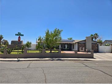 Charming single story home featuring desert landscaping, stone chimney, and solar panels at 4823 El Tesoro Ave, Las Vegas, NV 89121