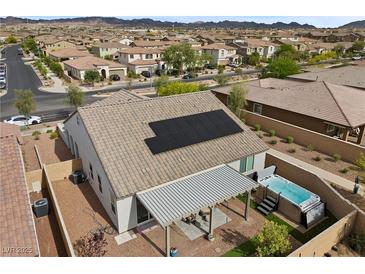 Aerial view of backyard with a hot tub, covered patio, and solar panels on the roof at 605 Cadence Vista Dr, Henderson, NV 89011