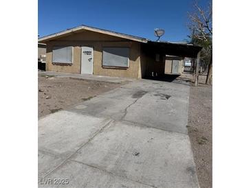 Modest single-story home with covered parking area and basic landscaping at 709 G St, Las Vegas, NV 89106