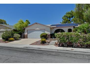 Charming single-story home featuring desert landscaping, a two-car garage, and solar panels for energy efficiency at 7100 Carrondale Way, Las Vegas, NV 89128