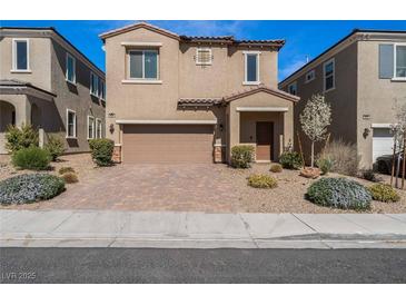 Inviting two-story home features a two-car garage, manicured landscaping, and a covered front porch entry at 9850 Poplar Point Ave, Las Vegas, NV 89178