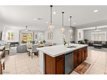 Bright open kitchen has a center island, wooden cabinets, and modern lighting at 10160 Tree Blossom Ave, Las Vegas, NV 89166