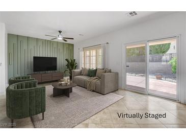 Bright living room with stylish decor, neutral tones, and sliding door access to the backyard at 2149 Kelsey Creek Ct, Henderson, NV 89044