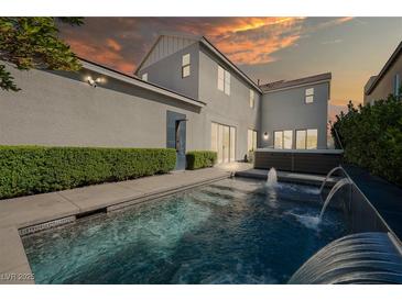 A luxurious backyard pool features a spa and a stunning waterfall, perfect for relaxation and entertainment at 2722 Marchetti Pl, Henderson, NV 89044