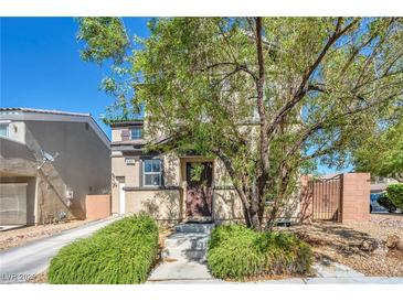 Charming two-story home featuring a well-manicured front yard with mature landscaping at 582 Brompton St, Las Vegas, NV 89178