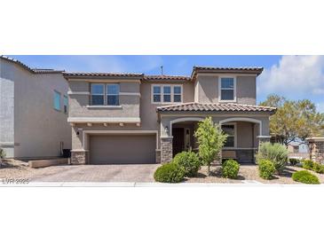 Two-story home with a two-car garage, landscaped front yard and covered porch with stone accents at 6370 Ava Ridge Ave, Las Vegas, NV 89141