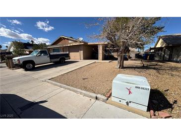 Modest single-story home with attached garage and desert landscaping at 7056 Sprucewood St, Las Vegas, NV 89147