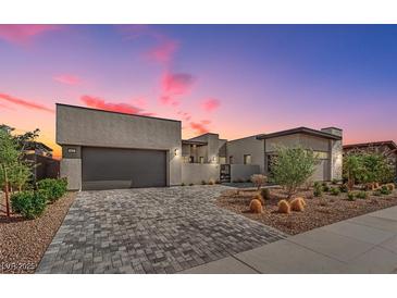 Stunning modern home with a beautiful brick driveway and desert landscaping at 818 Calluna St, Las Vegas, NV 89138