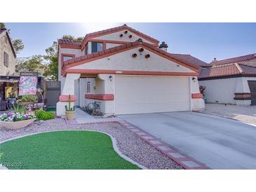 Charming home featuring stucco siding, a red tile roof, two-car garage, and xeriscaped yard at 117 Lotus Blossom Ct, Las Vegas, NV 89145