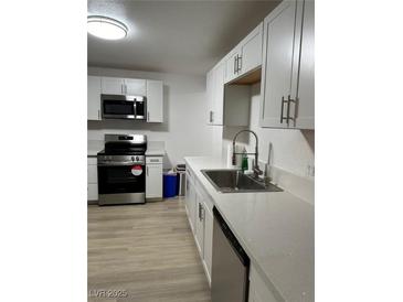 Updated kitchen featuring stainless steel appliances and bright white cabinets with modern hardware at 335 W Basic Rd, Henderson, NV 89015