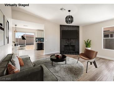 Inviting living room with modern furnishings, fireplace with stylish black tile and wood-look flooring at 5004 Celebrity Cir, Las Vegas, NV 89119