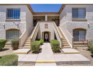 Inviting condo exterior with stucco, stairs, and lush landscaping at 5112 Harvest Time St # 201, Las Vegas, NV 89130