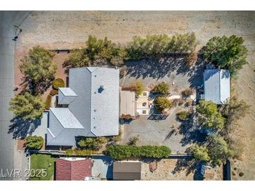 An aerial view of the property showcases the house, guest house, trees, landscaping, and surrounding desert terrain at 5981 Doubletree Rd, Pahrump, NV 89061
