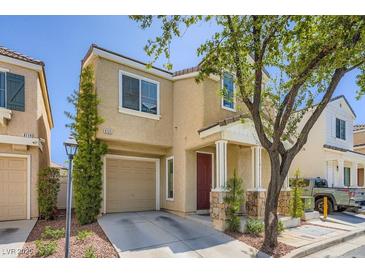 Inviting two-story home with a well-maintained lawn and a cozy front porch with stone accents at 6125 Broken Slate Way, Las Vegas, NV 89139