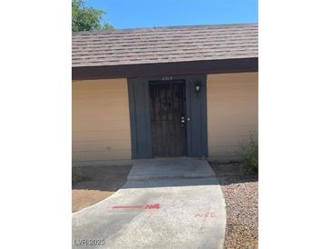 Charming front entrance featuring a secure black gate and concrete pathway at 6162 Meadow Vista Ln, Las Vegas, NV 89103