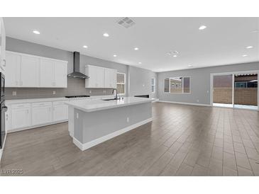 Modern kitchen features white cabinets, stainless steel appliances, and a spacious island at 851 Klamath Springs St, Henderson, NV 89011
