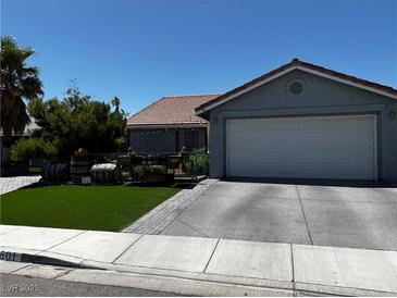 Charming home with a two-car garage, landscaped yard, and easy-to-maintain artificial grass at 3601 Slapton Ave, North Las Vegas, NV 89031
