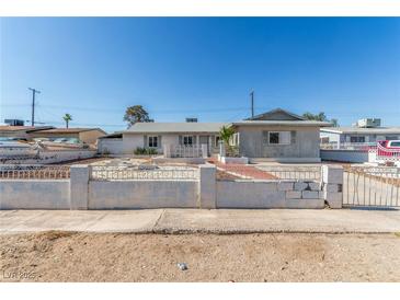 Single story home featuring a desert landscape with cinderblock and wrought iron fence in front at 1108 Princess Katy Ave, Las Vegas, NV 89119