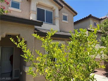 Two-story home featuring a stucco exterior, trimmed windows, and well-maintained landscaping at 248 Crystal Rose Ct, Las Vegas, NV 89106