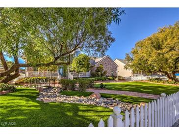 Beautifully landscaped front yard with lush greenery and a charming stone bridge at 5110 N Valadez St, Las Vegas, NV 89149