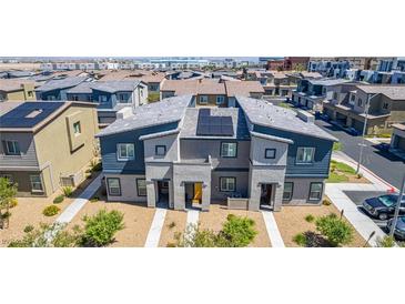 Two-story townhome with gray and blue exterior paint, solar panels, and small front yard landscaping at 527 Clearsable Ave, Henderson, NV 89044