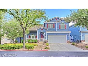 Charming two-story home with blue siding, red shutters, landscaped yard, and a two car garage at 7728 Whispering River St, Las Vegas, NV 89131
