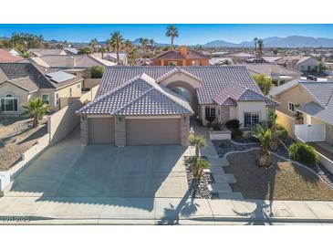 Inviting exterior elevation features a well-manicured yard and a spacious three-car garage at 816 Sandsprings St, Henderson, NV 89011