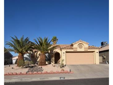 Charming single-story home featuring a two-car garage, desert landscaping, and two mature palm trees at 851 Brahma Ln, Henderson, NV 89002