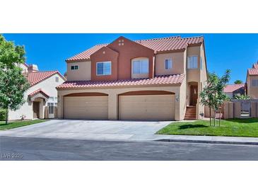 Inviting two-story home features a terracotta roof, tan stucco, and a two-car garage, set against a clear blue sky at 1663 Cloister Ave, Henderson, NV 89014