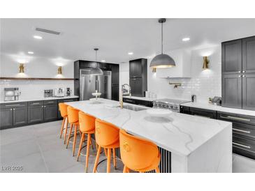 Bright, modern kitchen featuring a large island with seating and sleek, dark cabinetry at 3189 Montecito Dr, Las Vegas, NV 89120