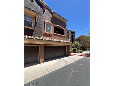 Exterior view showing the garage and the architecture of the townhome at 3975 N Hualapai Way # 246, Las Vegas, NV 89129