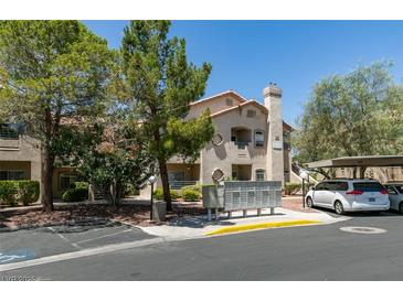 Inviting condo exterior features neutral stucco, covered parking, and mature landscaping at 5415 W Harmon Ave # 2075, Las Vegas, NV 89103