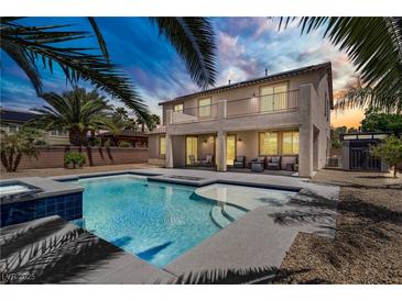 Backyard pool with hot tub and covered patio in a two-story home with wrought iron balcony at 6489 Crest Estates St, Las Vegas, NV 89131