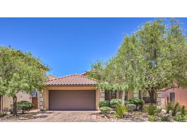 Charming single-story home featuring a terra cotta roof, desert landscaping, and a two-car garage at 7998 Base Camp Ave, Las Vegas, NV 89178