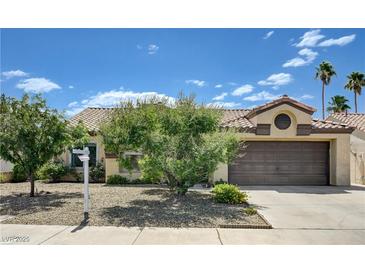 Charming single-story home featuring desert landscaping, a two-car garage, and mature trees in a residential neighborhood at 812 Bitterroot St, Henderson, NV 89002