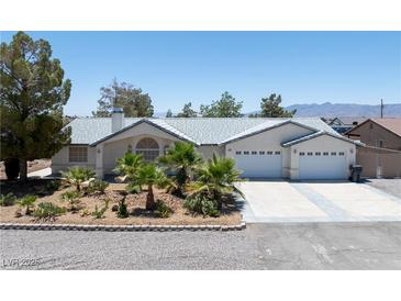 Charming single-story home with a well-manicured front yard and a two-car garage at 901 E Jaybird St, Pahrump, NV 89048