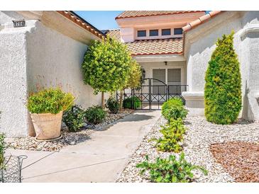 Inviting front yard featuring well-maintained landscaping and a secure gated entrance at 9704 Brawley Dr, Las Vegas, NV 89134