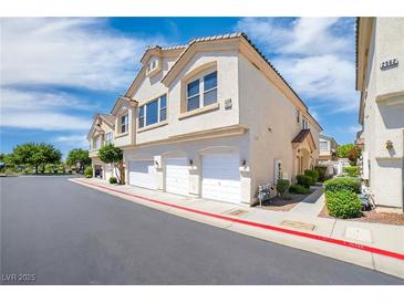 Charming townhome featuring multiple garages, complemented by well-maintained landscaping at 2558 Lazy Saddle Dr, Henderson, NV 89002