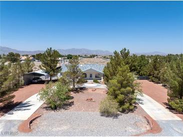 Charming home with desert landscaping, circular driveway, RV parking and mountain views at 2950 Winchester Ave, Pahrump, NV 89048