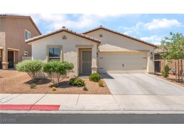 Charming single-story home featuring desert landscaping, a two-car garage, and a well-maintained front yard at 518 Descubir Ave, North Las Vegas, NV 89081